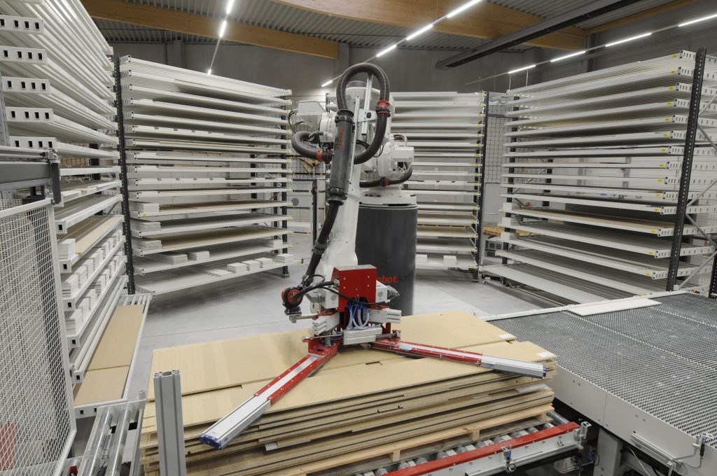 Der mit einem speziellen Vakuumgreifer ausgestattete Roboter lagert die zugeschnittenen Teile in Regalen zwischen und stapelt sie anschließend in der Reihenfolge der Weiterverarbeitung auf Paletten.
